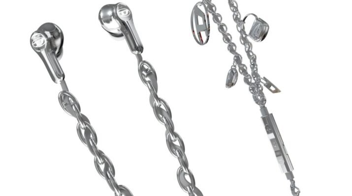Tampilan detail earphone kabel Diesel 60458 dengan aksen rantai metalik perak dan charm industrial yang kontras di atas latar belakang kain denim biru tua.