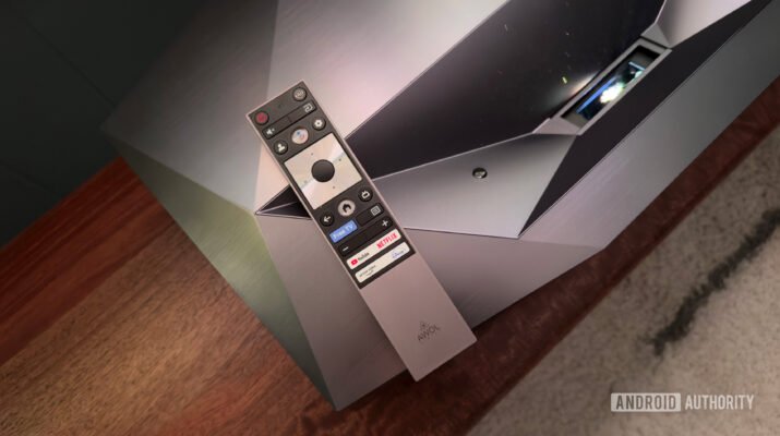 Visual setup home theater minimalis dengan proyektor menampilkan film di dinding putih besar, menciptakan suasana sinematik di ruang tamu modern.