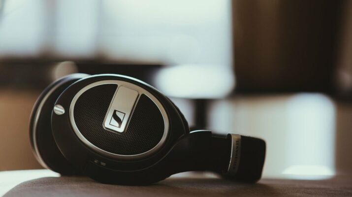 Visual dramatis sepasang headphone premium yang sedang diuji di laboratorium dengan latar belakang grafik molekul kimia bisphenol dan plastik sintetis.