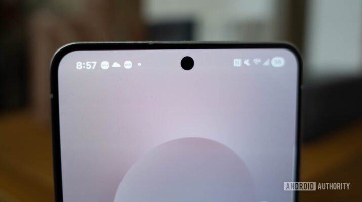 Seseorang sedang memotret pemandangan kota malam hari menggunakan smartphone flagship dengan tampilan antarmuka kamera pro mode yang kompleks.