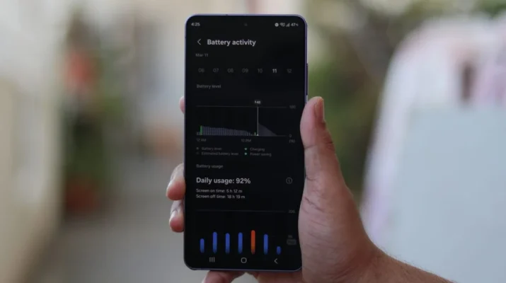alt text: Tampilan depan Galaxy S26 Ultra diletakkan di atas charger nirkabel sambil menampilkan grafik pengisian daya yang cepat di layar, menunjukkan peningkatan kecepatan 25W dibandingkan model sebelumnya.